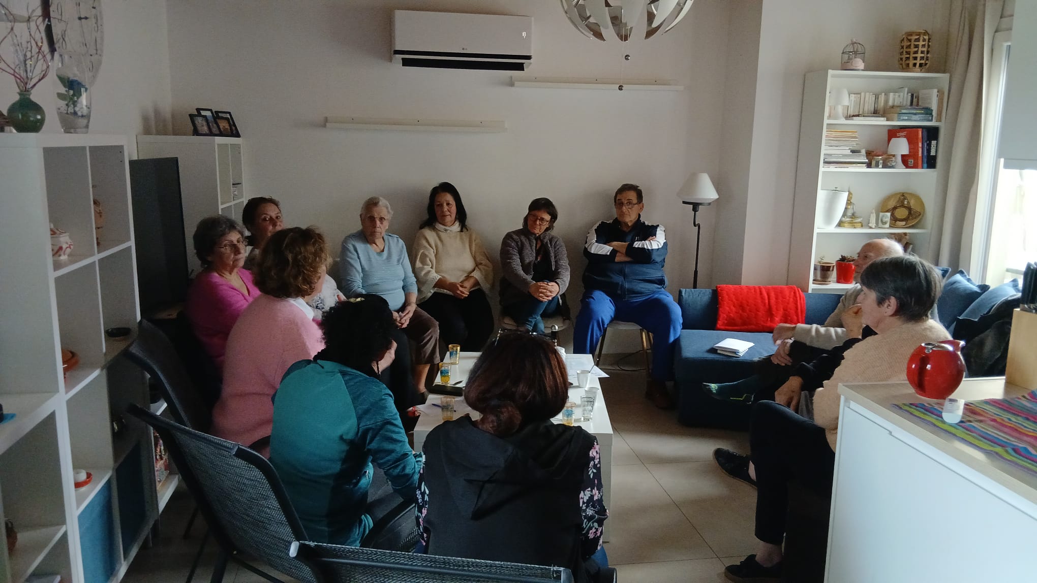 Réunion intime chez l'habitant — cercle de personnes dans un salon