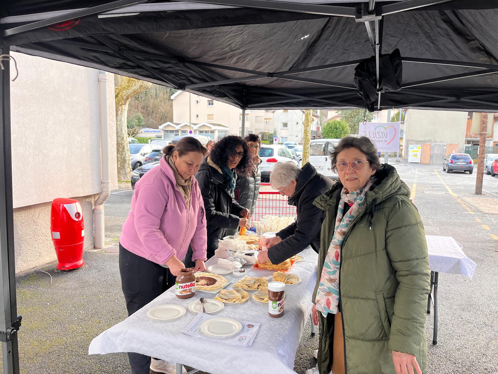 Stand crêpes au marché — équipe sous tente noire, Nutella visible, logo VeM