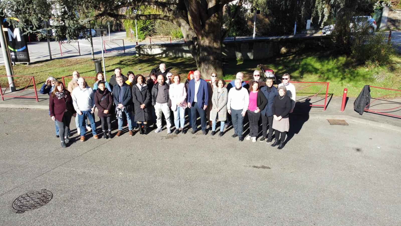 Photo de groupe — vue depuis la rue, toute la liste alignée au soleil