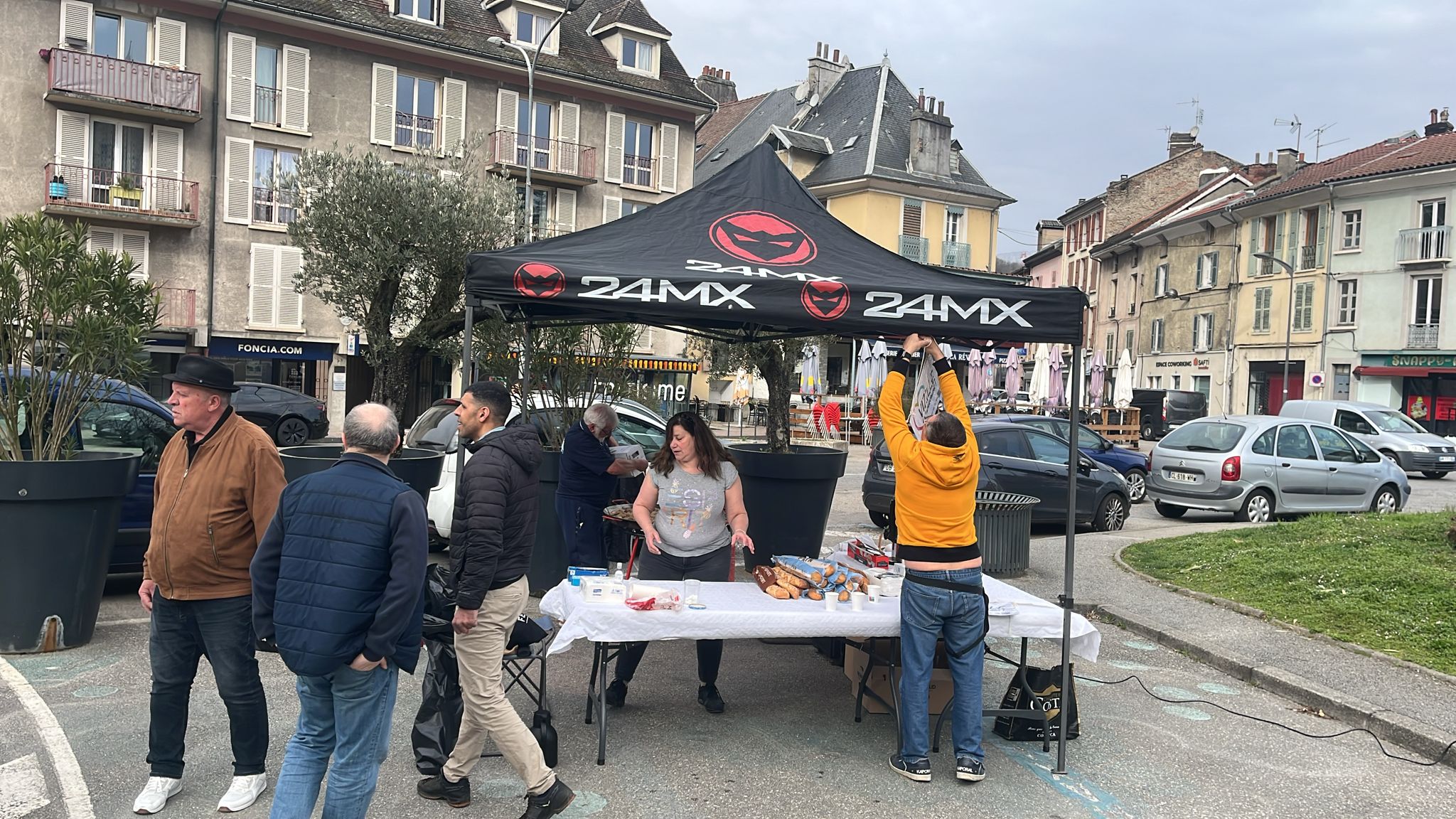 Installation matinale du stand — tente, table, équipe en action
